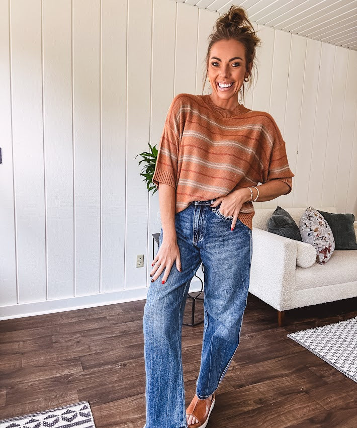 Lightweight, striped drop shoulder sweater tee in a soft sage or rust base  with warm stripes of light brown, taupe, and spice, and ribbed detailing at the neck, cuffs, and hem.