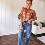 High-rise fit with a curved, architectural leg, rigid denim front, stretch fabric, top block, curved outer seam, and tapered hem that create a modern "barrel" or "horseshoe" shape sitting away from the leg.