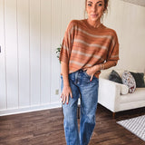 Lightweight, striped drop shoulder sweater tee in a soft sage or rust base  with warm stripes of light brown, taupe, and spice, and ribbed detailing at the neck, cuffs, and hem.