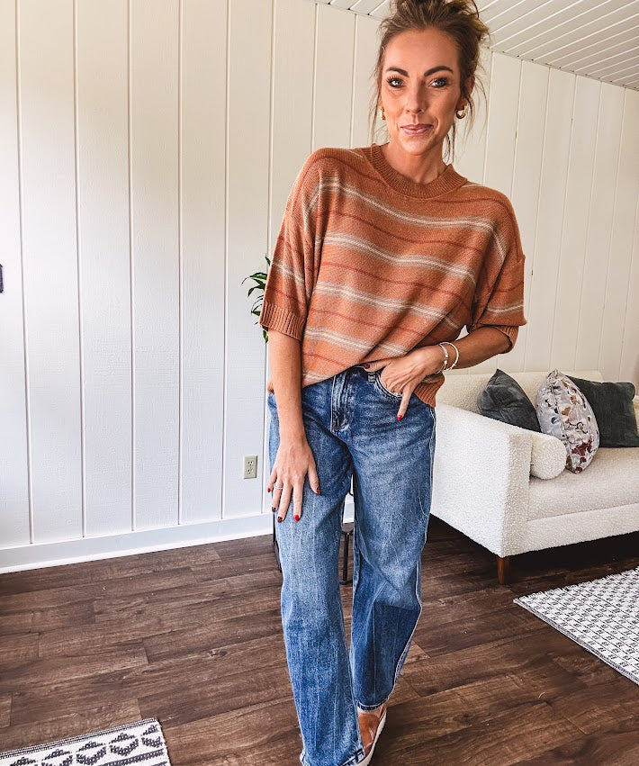 Lightweight, striped drop shoulder sweater tee in a soft sage or rust base  with warm stripes of light brown, taupe, and spice, and ribbed detailing at the neck, cuffs, and hem.