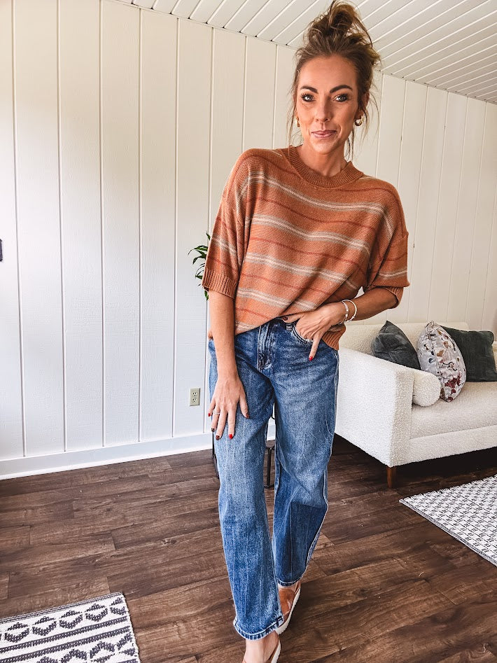 Lightweight, striped drop shoulder sweater tee in a soft sage or rust base  with warm stripes of light brown, taupe, and spice, and ribbed detailing at the neck, cuffs, and hem.