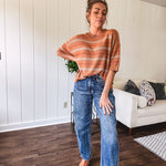 High-rise fit with a curved, architectural leg, rigid denim front, stretch fabric, top block, curved outer seam, and tapered hem that create a modern "barrel" or "horseshoe" shape sitting away from the leg.