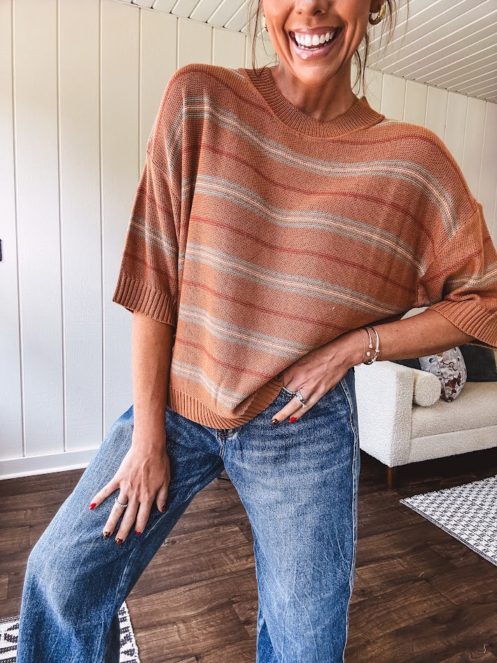 Lightweight, striped drop shoulder sweater tee in a soft sage or rust base  with warm stripes of light brown, taupe, and spice, and ribbed detailing at the neck, cuffs, and hem.