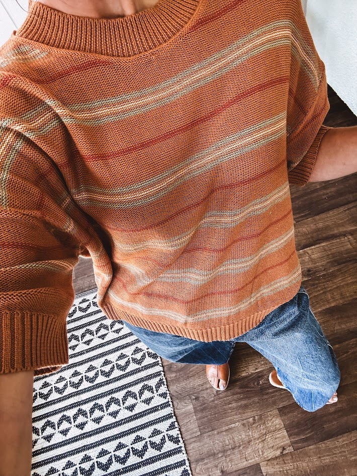 Lightweight, striped drop shoulder sweater tee in a soft sage or rust base  with warm stripes of light brown, taupe, and spice, and ribbed detailing at the neck, cuffs, and hem.