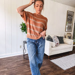 Lightweight, striped drop shoulder sweater tee in a soft sage or rust base  with warm stripes of light brown, taupe, and spice, and ribbed detailing at the neck, cuffs, and hem.
