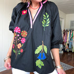 Black cotton top with mock collar and V neck, 3/4 balloon sleeves, pink trim at the neck and bright embroidered pink, green and blue florals.