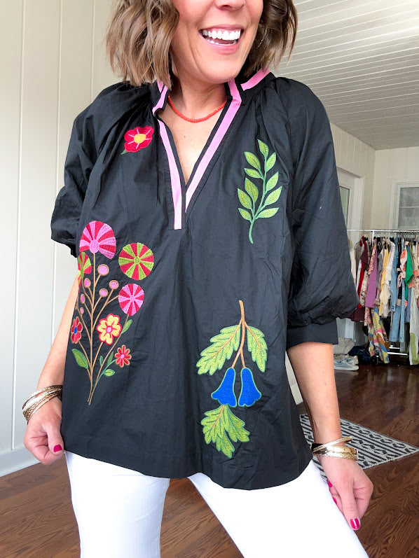 Black cotton top with mock collar and V neck, 3/4 balloon sleeves, pink trim at the neck and bright embroidered pink, green and blue florals.