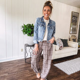 Medium wash non-stretch denim jacket with classic trim, raw, uneven hem and cuffs with silver hardware and cropped length.