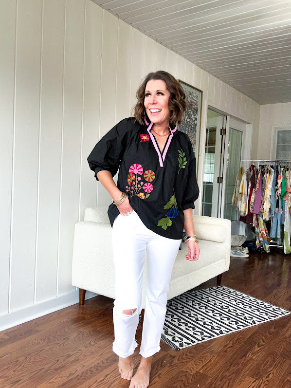 Black cotton top with mock collar and V neck, 3/4 balloon sleeves, pink trim at the neck and bright embroidered pink, green and blue florals.