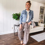 Medium wash non-stretch denim jacket with classic trim, raw, uneven hem and cuffs with silver hardware and cropped length.