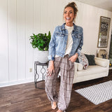 Medium wash non-stretch denim jacket with classic trim, raw, uneven hem and cuffs with silver hardware and cropped length.
