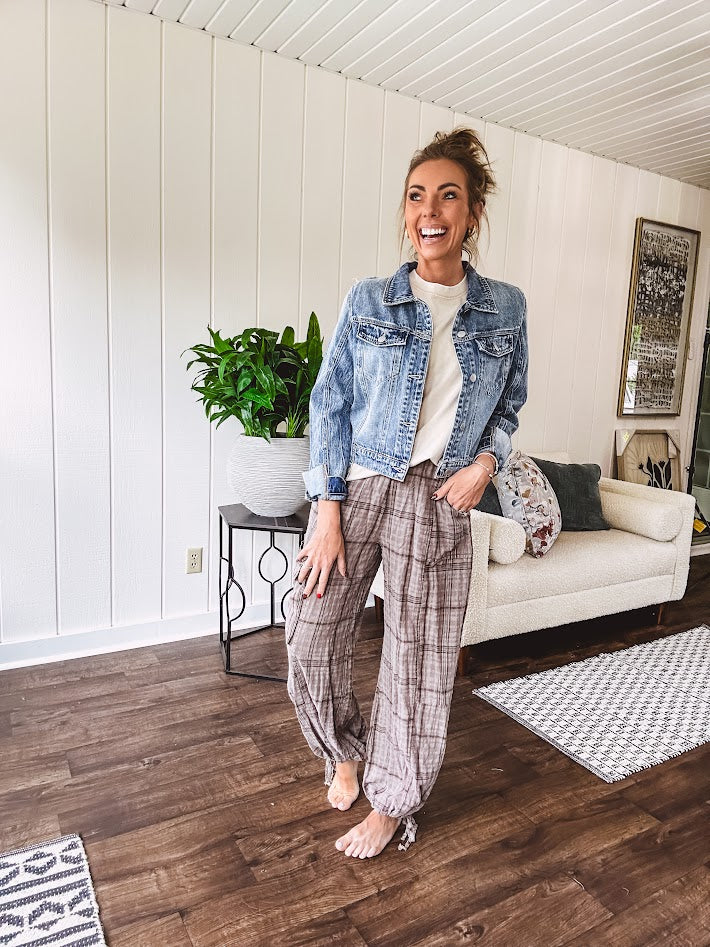 Medium wash non-stretch denim jacket with classic trim, raw, uneven hem and cuffs with silver hardware and cropped length.