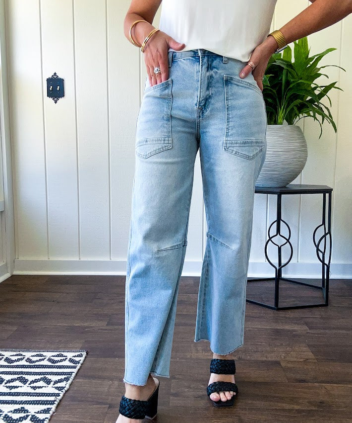 Light wash barrel jeans with extra large pockets and flared, raw hems.