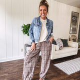 Medium wash non-stretch denim jacket with classic trim, raw, uneven hem and cuffs with silver hardware and cropped length.