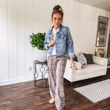 Medium wash non-stretch denim jacket with classic trim, raw, uneven hem and cuffs with silver hardware and cropped length.