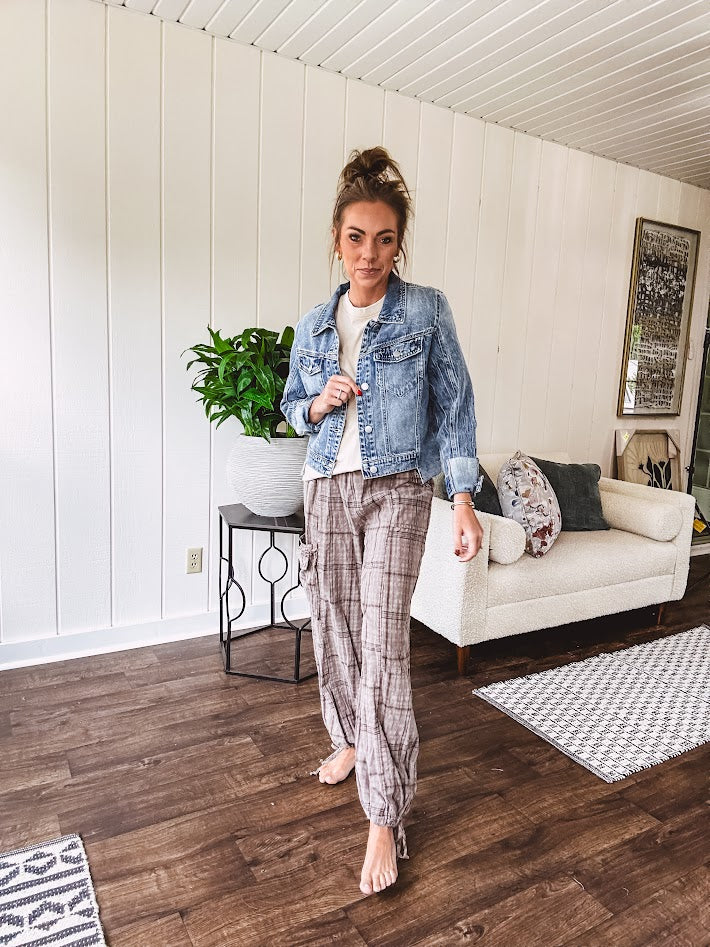 Medium wash non-stretch denim jacket with classic trim, raw, uneven hem and cuffs with silver hardware and cropped length.