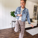 Medium wash non-stretch denim jacket with classic trim, raw, uneven hem and cuffs with silver hardware and cropped length.