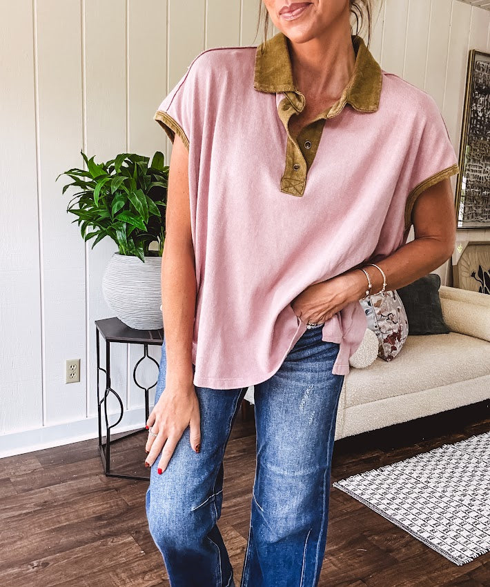 Soft, terry-like mauve top with cap sleeves, collar and split hem with contrasting olive at collar, three button front and cuffs.