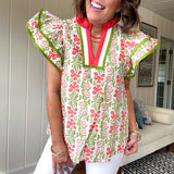 White cotton blouse with coral and lime florals and stripes at the ruffled collar and V neck, flutter sleeves with lime trim, flowy hem.