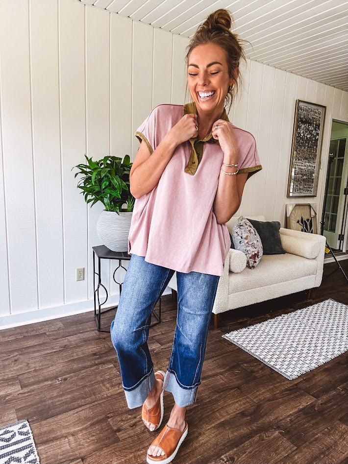 Soft, terry-like mauve top with cap sleeves, collar and split hem with contrasting olive at collar, three button front and cuffs.