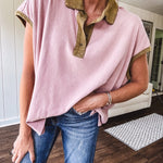 Soft, terry-like mauve top with cap sleeves, collar and split hem with contrasting olive at collar, three button front and cuffs.