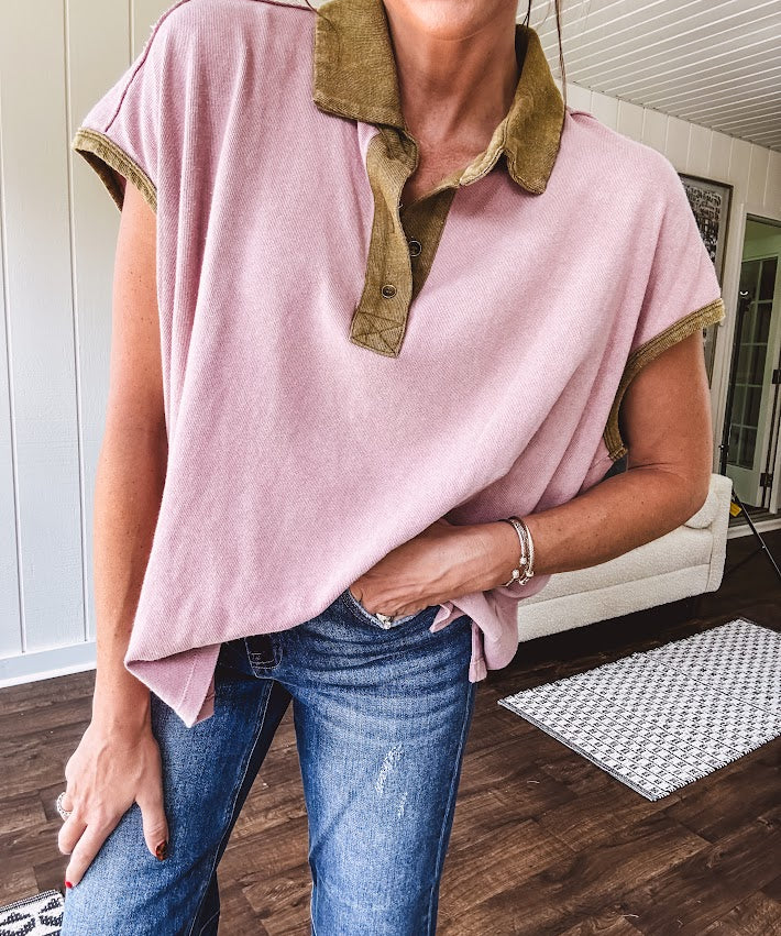 Soft, terry-like mauve top with cap sleeves, collar and split hem with contrasting olive at collar, three button front and cuffs.