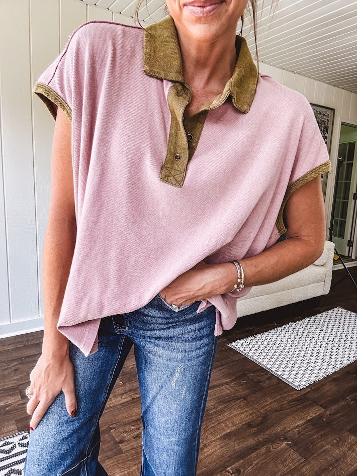 Soft, terry-like mauve top with cap sleeves, collar and split hem with contrasting olive at collar, three button front and cuffs.