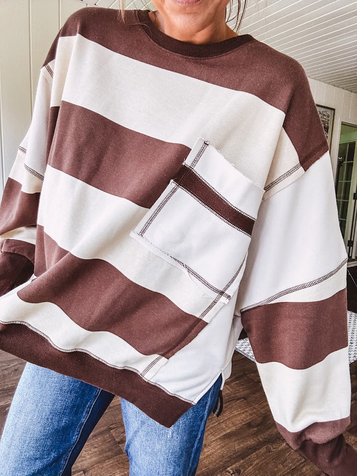 Oversized terry knit long sleeved pullover in brown and ivory large stripes, oversized front pocket, wide hem and cuffs and split hem.