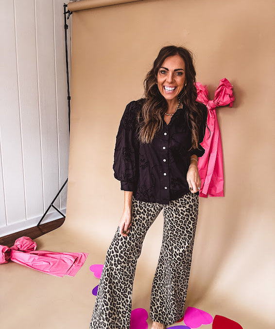 Black button down with tapestry embroidery pattern, ruffled V-neckline, and cuffed, balloon sleeves.
