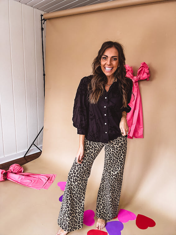 Black button down with tapestry embroidery pattern, ruffled V-neckline, and cuffed, balloon sleeves.