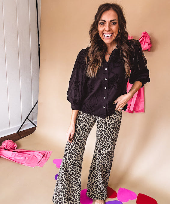 Black button down with tapestry embroidery pattern, ruffled V-neckline, and cuffed, balloon sleeves.