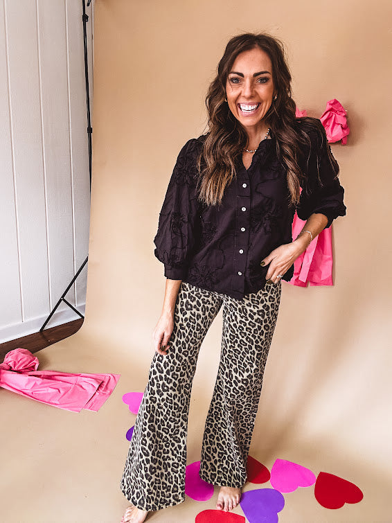 Black button down with tapestry embroidery pattern, ruffled V-neckline, and cuffed, balloon sleeves.