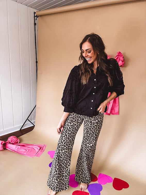 Black button down with tapestry embroidery pattern, ruffled V-neckline, and cuffed, balloon sleeves.