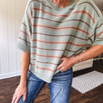 Lightweight, striped drop shoulder sweater tee in a soft sage or rust base  with warm stripes of light brown, taupe, and spice, and ribbed detailing at the neck, cuffs, and hem.