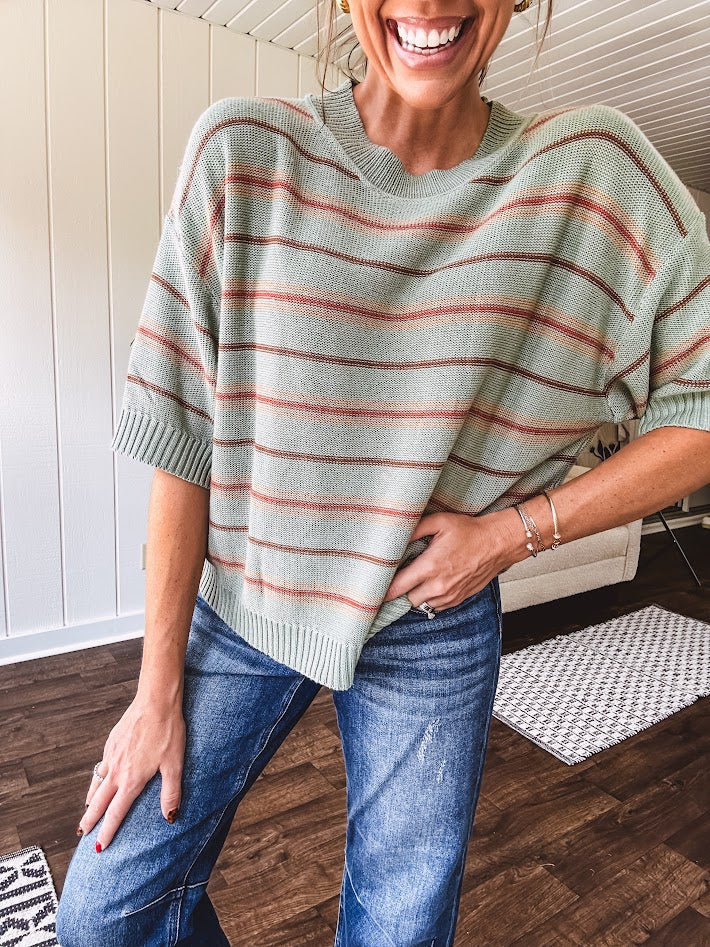 Lightweight, striped drop shoulder sweater tee in a soft sage or rust base  with warm stripes of light brown, taupe, and spice, and ribbed detailing at the neck, cuffs, and hem.