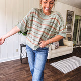 Lightweight, striped drop shoulder sweater tee in a soft sage or rust base  with warm stripes of light brown, taupe, and spice, and ribbed detailing at the neck, cuffs, and hem.