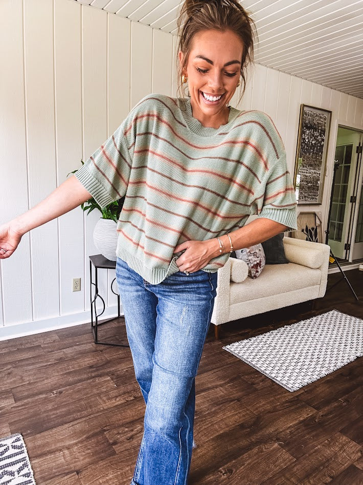 Lightweight, striped drop shoulder sweater tee in a soft sage or rust base  with warm stripes of light brown, taupe, and spice, and ribbed detailing at the neck, cuffs, and hem.