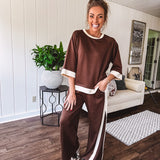 Cocoa brown super soft set with ivory trim at the round neck, cuffs and pleated side trim on the matching pants with elastic waist and pockets. 3/4 sleeve, oversized fit.