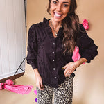 Black button down with tapestry embroidery pattern, ruffled V-neckline, and cuffed, balloon sleeves.