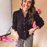 Black button down with tapestry embroidery pattern, ruffled V-neckline, and cuffed, balloon sleeves.