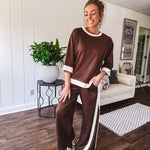 Cocoa brown super soft set with ivory trim at the round neck, cuffs and pleated side trim on the matching pants with elastic waist and pockets. 3/4 sleeve, oversized fit.