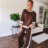 Cocoa brown super soft set with ivory trim at the round neck, cuffs and pleated side trim on the matching pants with elastic waist and pockets. 3/4 sleeve, oversized fit.