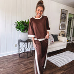 Cocoa brown super soft set with ivory trim at the round neck, cuffs and pleated side trim on the matching pants with elastic waist and pockets. 3/4 sleeve, oversized fit.