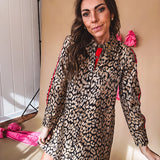Leo print gold metallic button down dress with red stripes on the sleeves. Metal buttons, a collar, and functional pockets