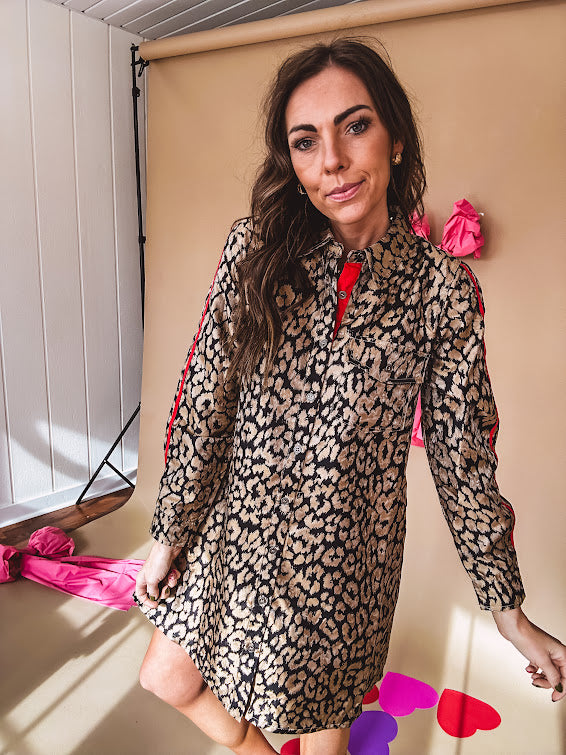 Leo print gold metallic button down dress with red stripes on the sleeves. Metal buttons, a collar, and functional pockets