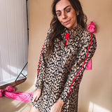 Leo print gold metallic button down dress with red stripes on the sleeves. Metal buttons, a collar, and functional pockets