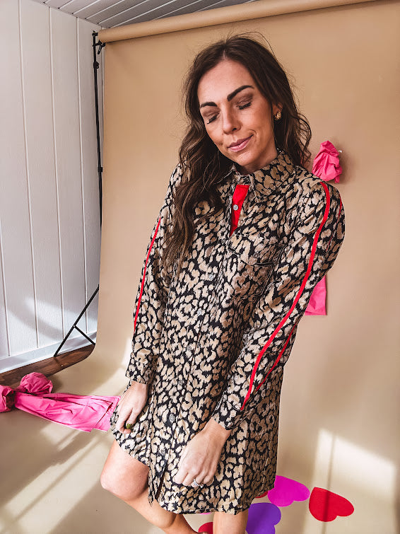 Leo print gold metallic button down dress with red stripes on the sleeves. Metal buttons, a collar, and functional pockets