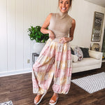 Lightweight cotton balloon style pants with elastic waist and cuffs, side pockets and pastel taupe, pink and coral paisley bandana print.
