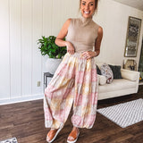 Lightweight cotton balloon style pants with elastic waist and cuffs, side pockets and pastel taupe, pink and coral paisley bandana print.