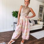 Lightweight cotton balloon style pants with elastic waist and cuffs, side pockets and pastel taupe, pink and coral paisley bandana print.